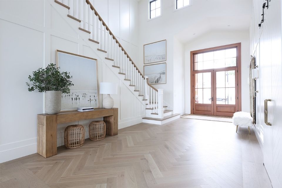 Bright entryway with grand staircase and wood floors 